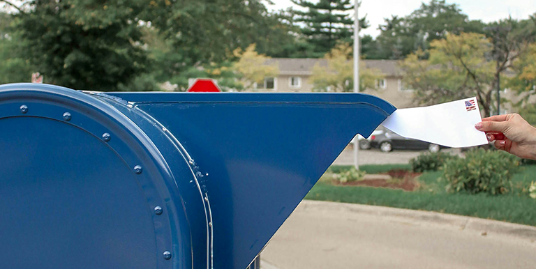 Letter going into a USPS mailbox