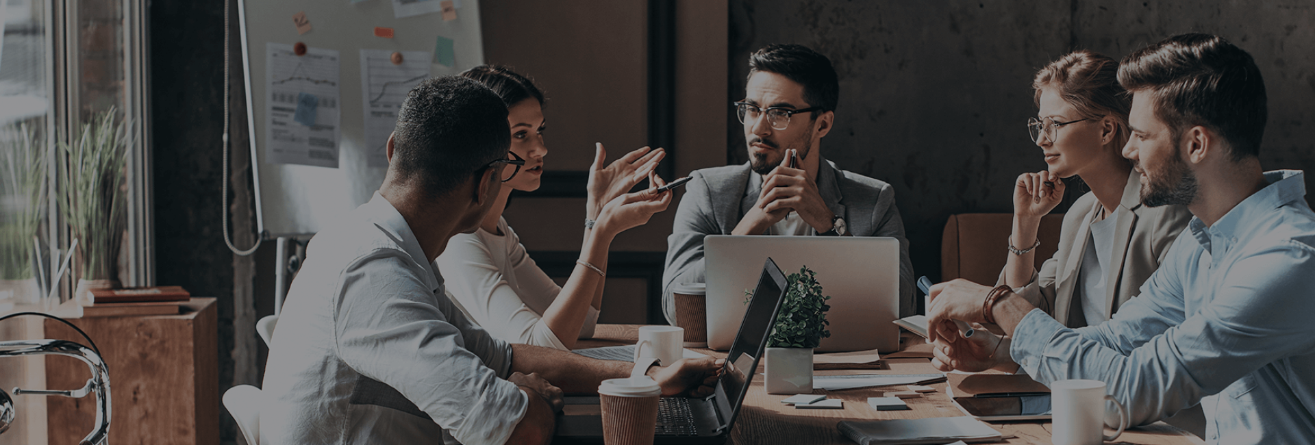 Team of coworkers sitting at a table conducting a meeting