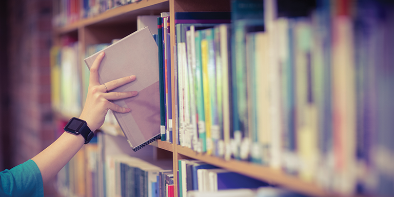 Lady taking a book off the shelf