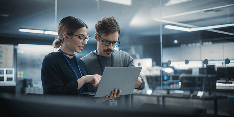 Man and Woman Looking at a Laptop
