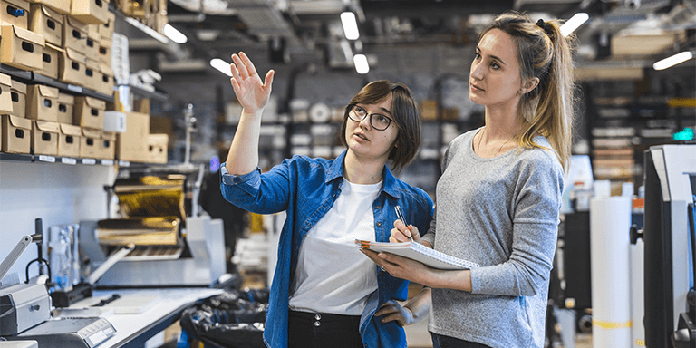 Two women looking at inventory on a shelf
